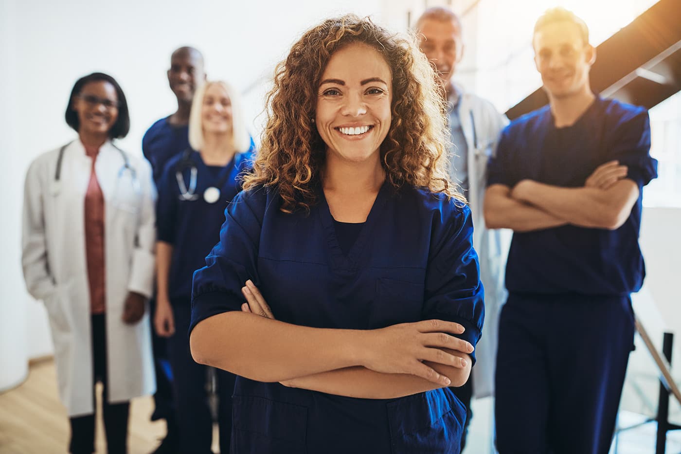 Smiling female doctor standing with medical staff in a hospital 