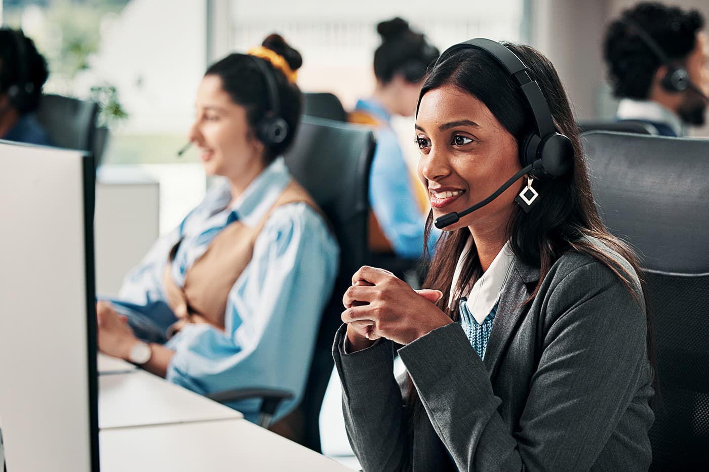 Call center, computer and woman in office, internet or communication with system solution. Employees, help desk and people with pc, coworking or contact us with conversation, crm and customer service