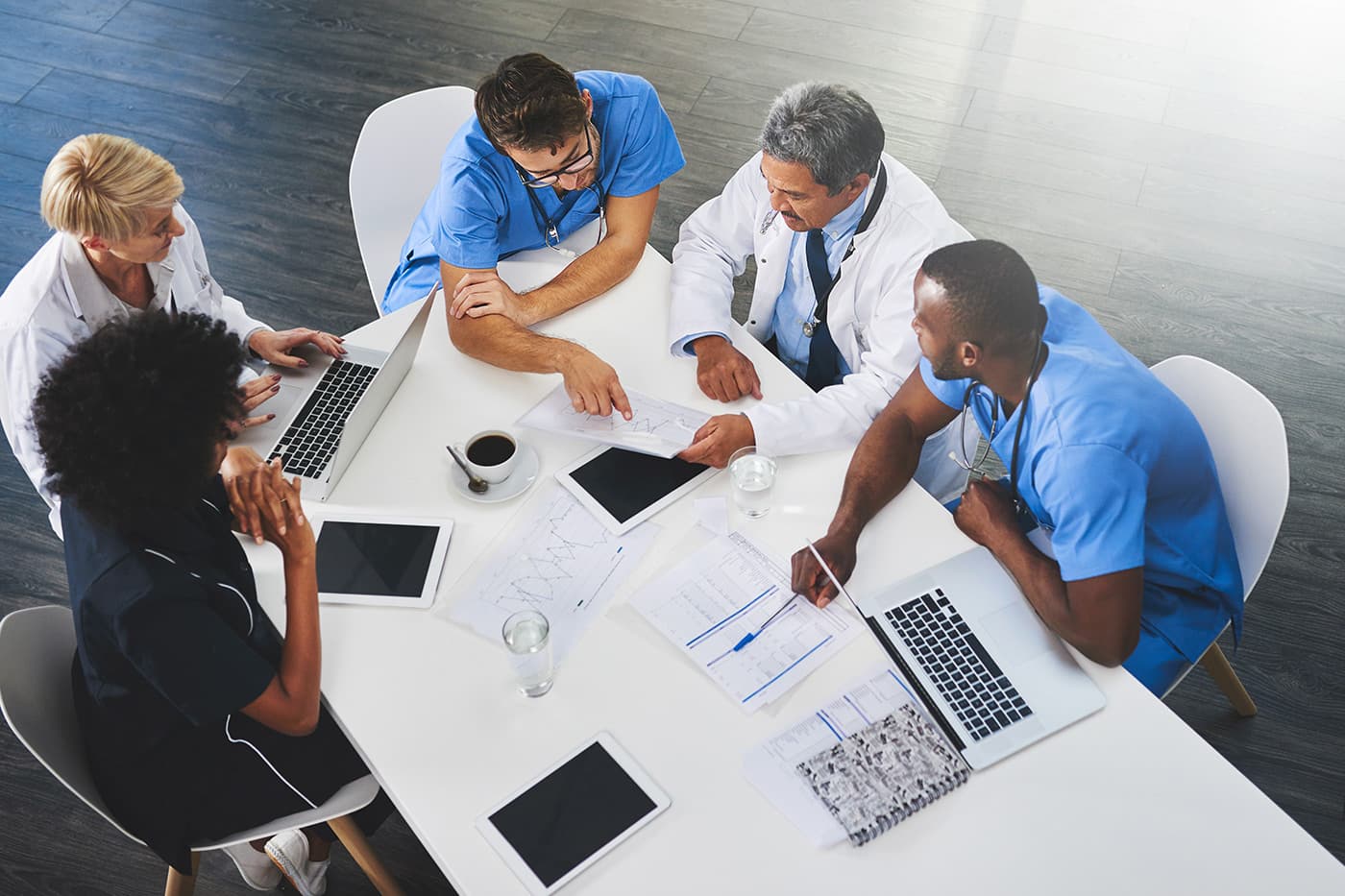 https://stock.adobe.com/images/team-of-medical-workers-sitting-and-meeting-with-laptops-around-table-doctors-and-staff-discussing-papers-and-test-results-healthcare-experts-handling-daily-tasks-and-duties/521124772