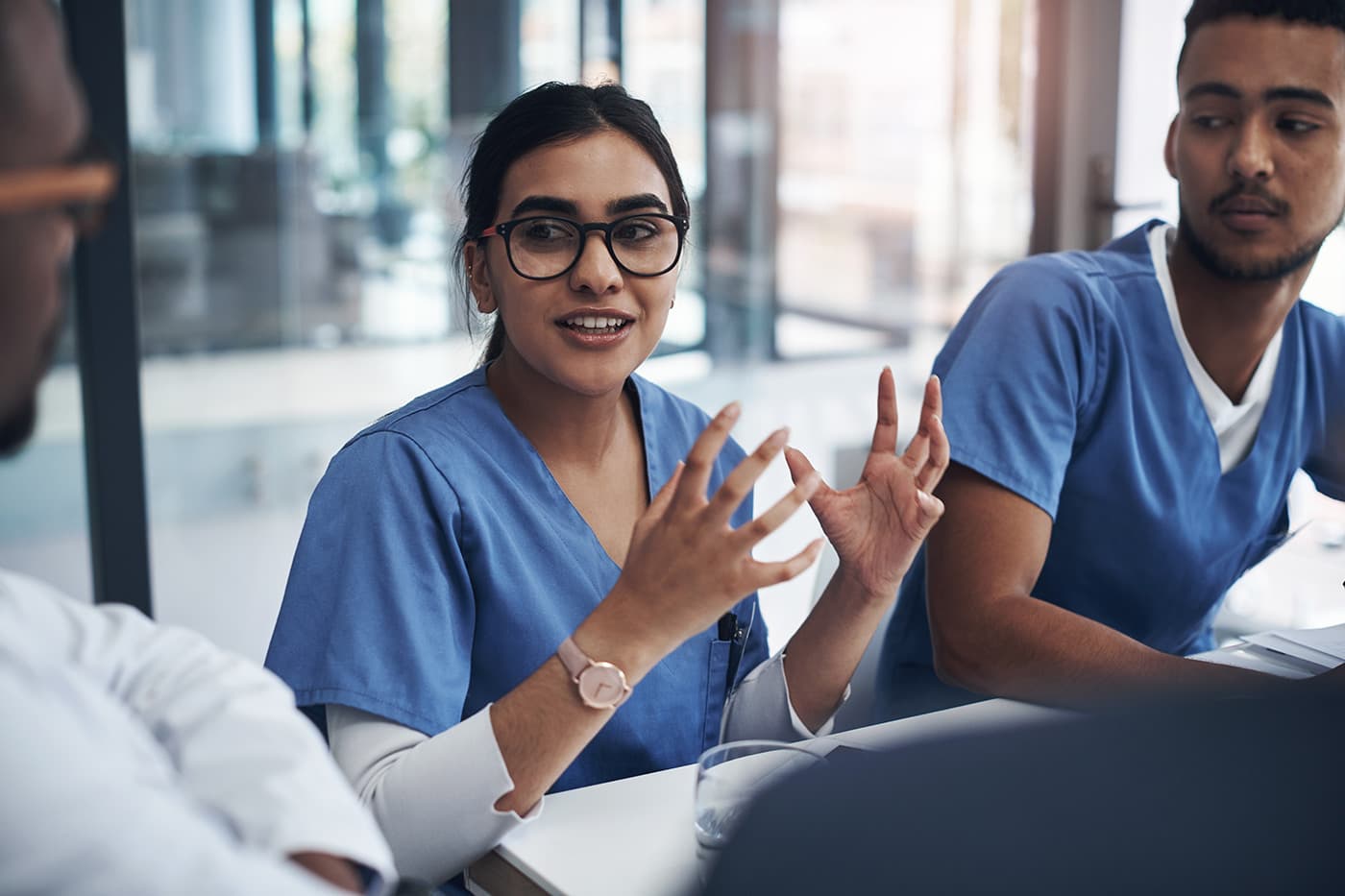 Healthcare, medical team in a meeting and talking in conference room. Medicine discussion or communication, teamwork or collaboration and doctors or nurses speaking about confidential patient data