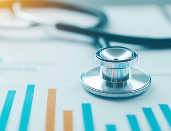 A stethoscope resting on printed bar charts and data reports.